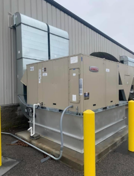 Commercial rooftop HVAC unit beside a building