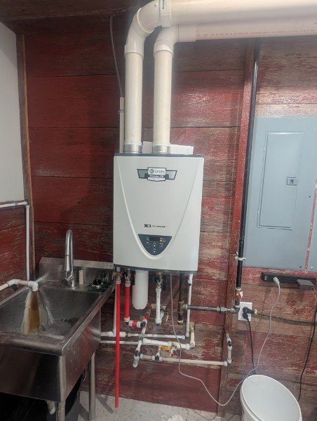 Wall-mounted tankless water heater and piping